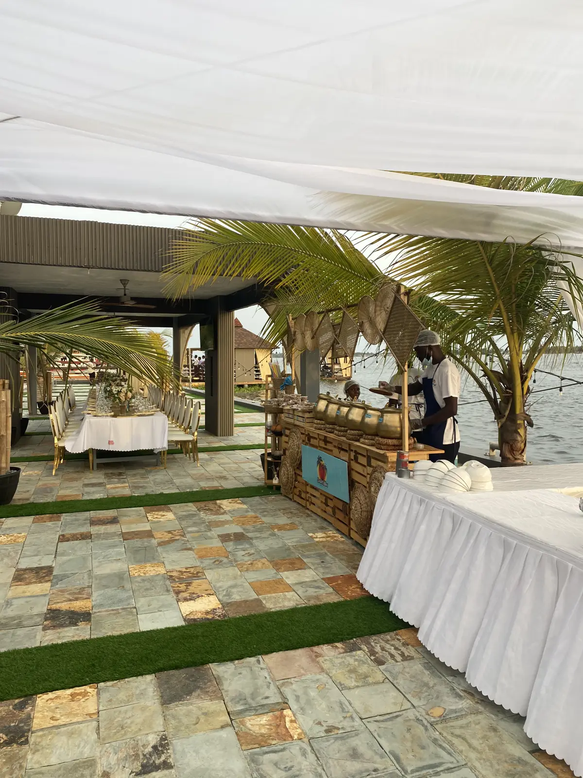 A canopied buffet line laid out on the waterfront terrace