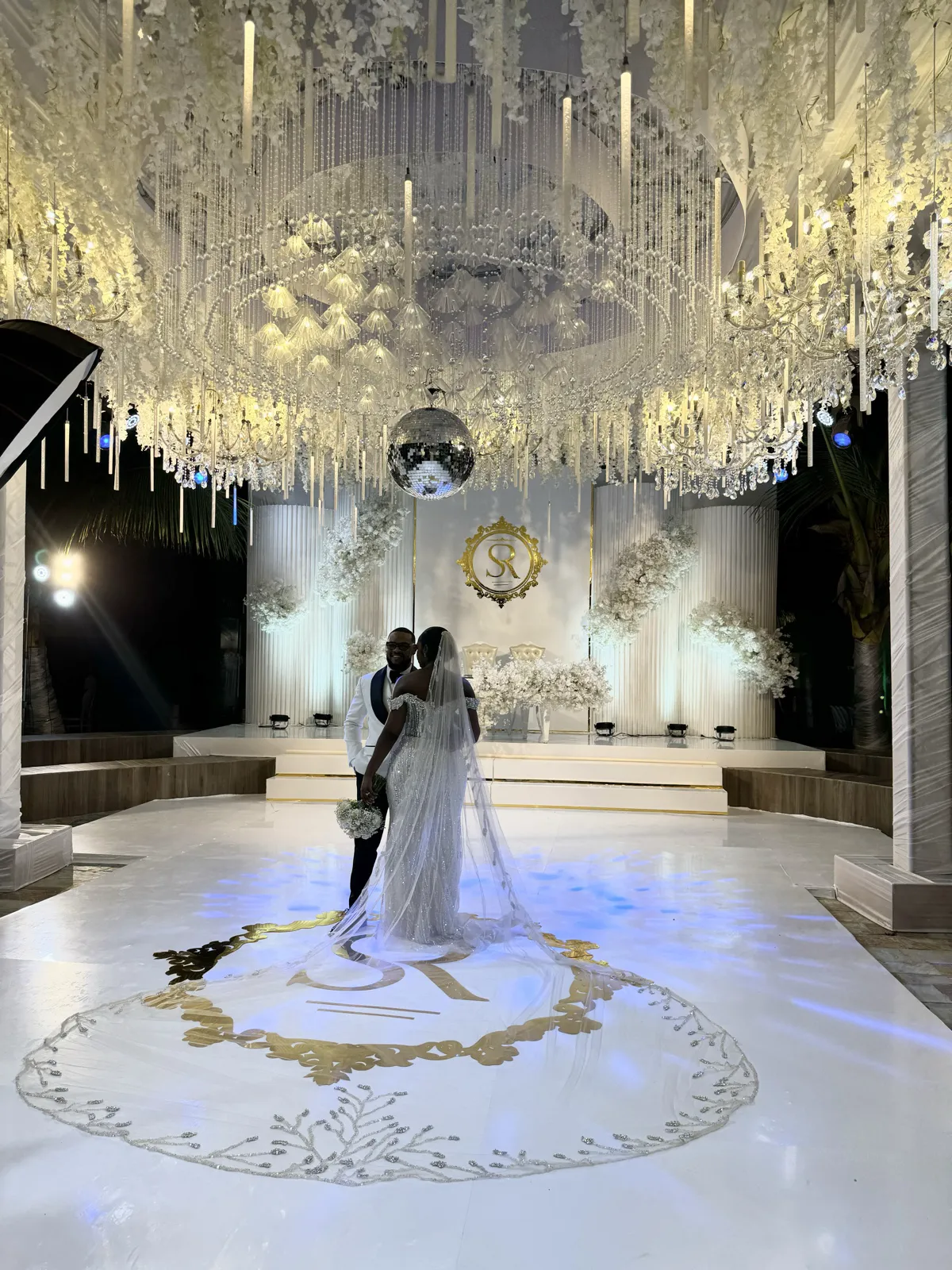 A couple’s first dance beneath a chandelier canopy